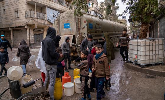 叙利亚北部阿勒颇市阿尔米亚萨尔社区的分发点，当地居民正用塑料桶装取干净的饮用水。